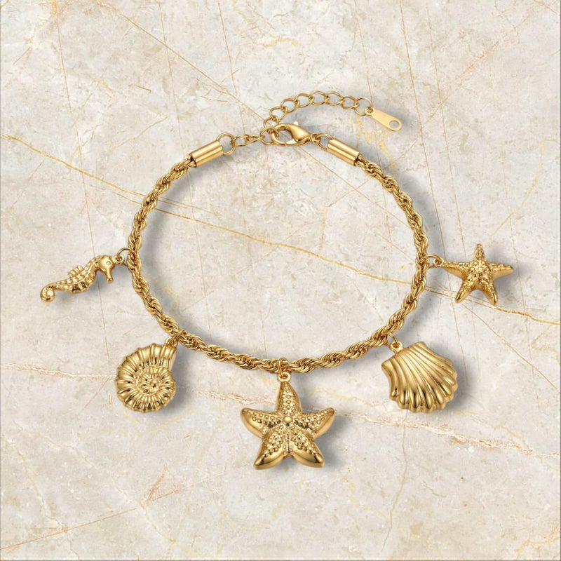 انسيال ذهبي أنيق مصنوع من الستانلس ستيل المقاوم للصدأ، بسلسلة مجدولة راقية تزينها دلايات أصداف ونجوم بحر بتفاصيل بارزة، مع قفل قابل للتعديل ليناسبكِ. - Image 5